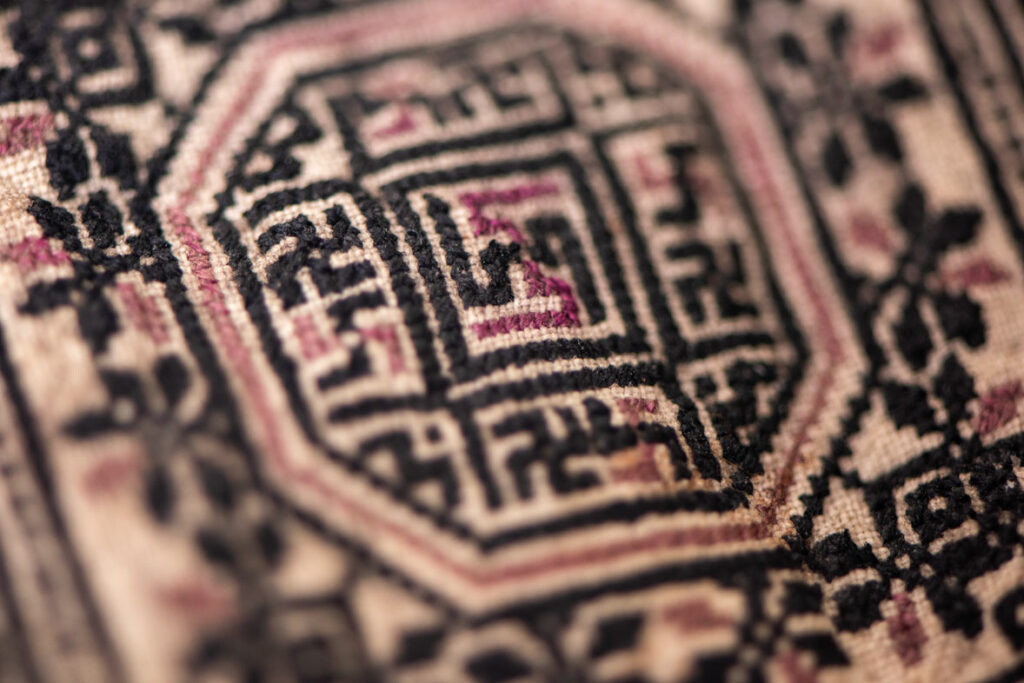 Ceremonial betel nut bag from the ami tribe, fully embroidered with distinctive motifs and inverted trapezoid shape.
