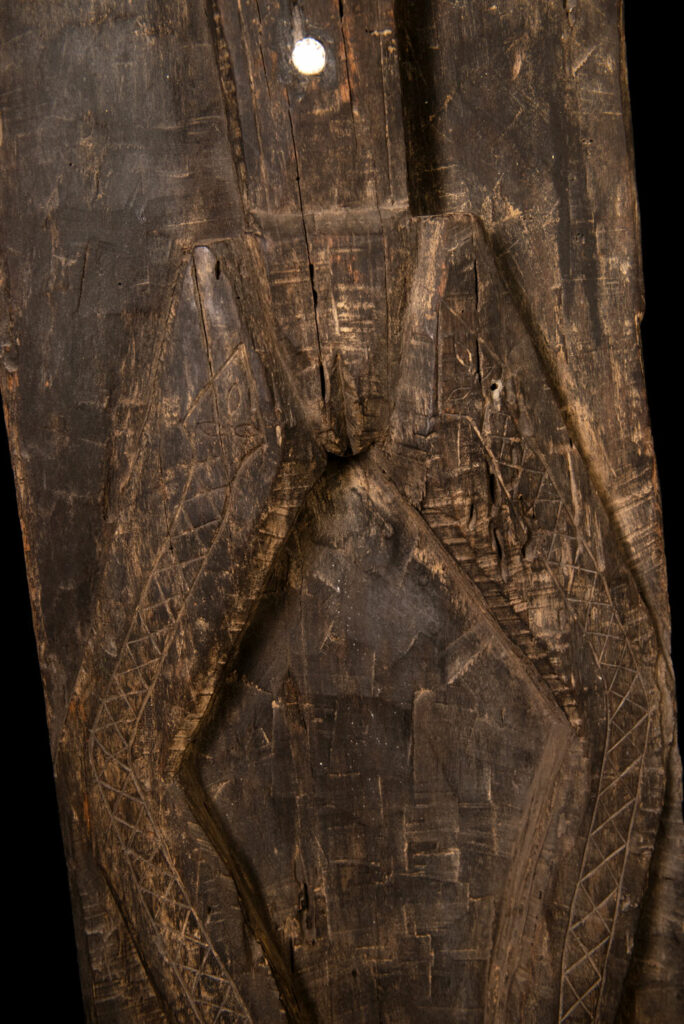Pair of Paiwan Tribe Ancestor Panels, likely from Laiyi, carved with two figures—a male and a female. Their eyes, mouth, nipples, and navel are inlaid with porcelain. Their arms and legs are decorated with tribal motifs suggesting tattoos. Both figures wear hats, and the snakes carved above their heads indicate that they were important members of the nobility.