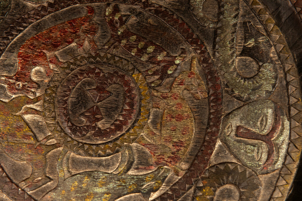 Ceremonial Tray from the Paiwan Tribe Carved with snakes, human faces, and game animals such as deer and wild boar, topped with a sculpture of a deer .