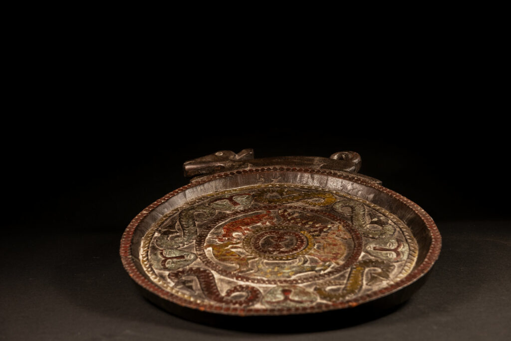 Ceremonial Tray from the Paiwan Tribe Carved with snakes, human faces, and game animals such as deer and wild boar, topped with a sculpture of a deer .