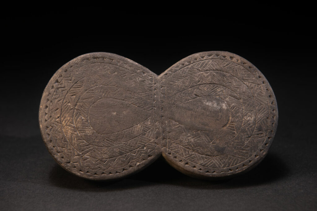 Carved wooden box from the Yami tribe containing a men’s silver necklace called obai.