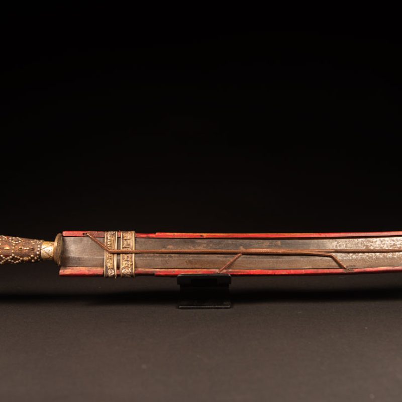 Typical Rukai-style sword with a wooden handle inlaid with steel wire and nail heads. The guard is made from a Chinese coin.