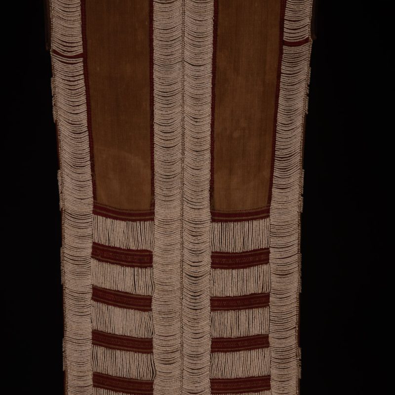 Long Atayal tribe sleeveless tunic with an open front and no collar. Made from linen and decorated with dark red wool, its most striking feature lies in the elaborate use of cylindrical clam-shell beads, which are carefully embedded into the fabric in both horizontal and vertical alignments.