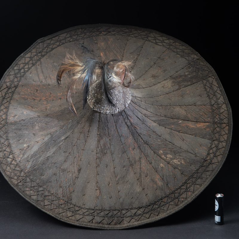 This ancient hat from the Yami- Tao tribes, orchid Island, Taiwan was worn by the female for work in the fields It is named “Varogot”. It is done with coconut palm bark, rotaing, aluminium and feathers for the top decoration..