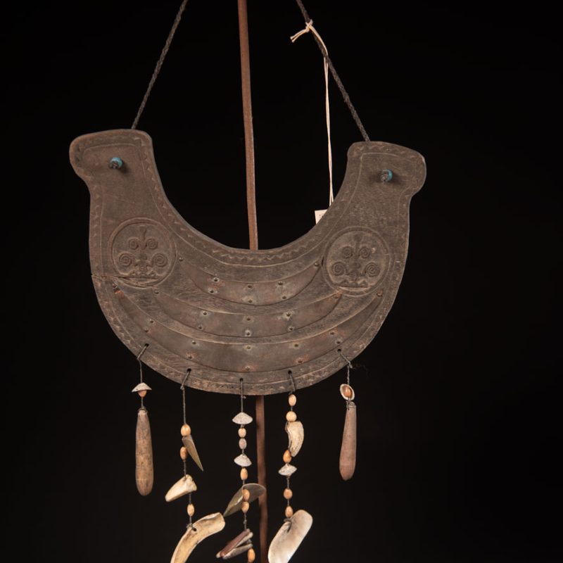 This half-moon-shaped chest ornament is made from wood chips of mangosteen, wuzhi (five-finger tree), or persimmon trees, and is traditionally worn by elderly men. Three arc-shaped copper pieces ( oxyded) of varying sizes are attached to the wooden base. The lower edge is adorned with various decorative elements considered beautiful.