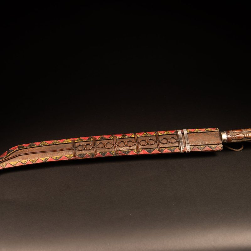 Very long Paiwan ceremonial sword featuring a scabbard carved with a snake and three human faces.