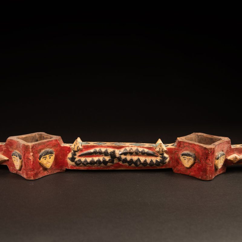 wine double cup engraved with snakes on the handles and in the center of the cup, and with human faces on the containers. The whole piece is enhanced with red, black, white, and green paint.