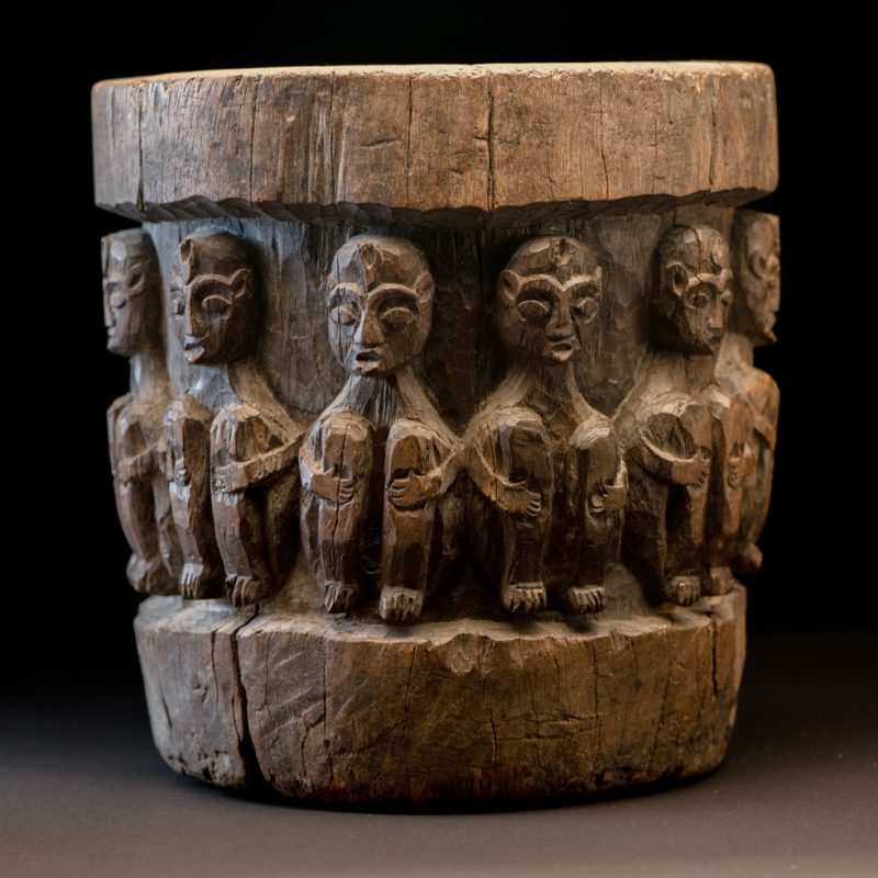 Small ancient mortar from the Paiwan tribe, richly carved around its circumference with a chain of crouching Paiwan figures.