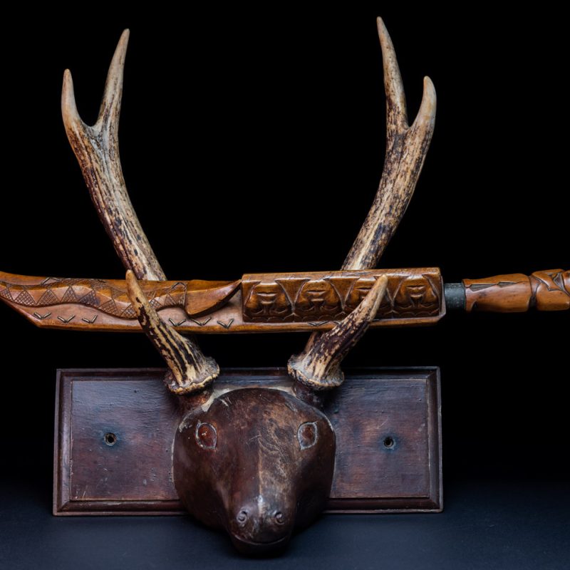 Very fine sword from the Paiwan tribe, carved with the sacred snake and human faces along the sides. The hilt features a full-length standing figure.