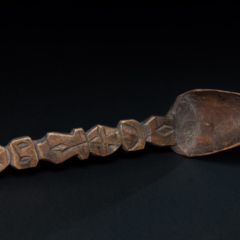 Old spoon from the Paiwan tribe, carved with two full-length standing figures, one above the other.