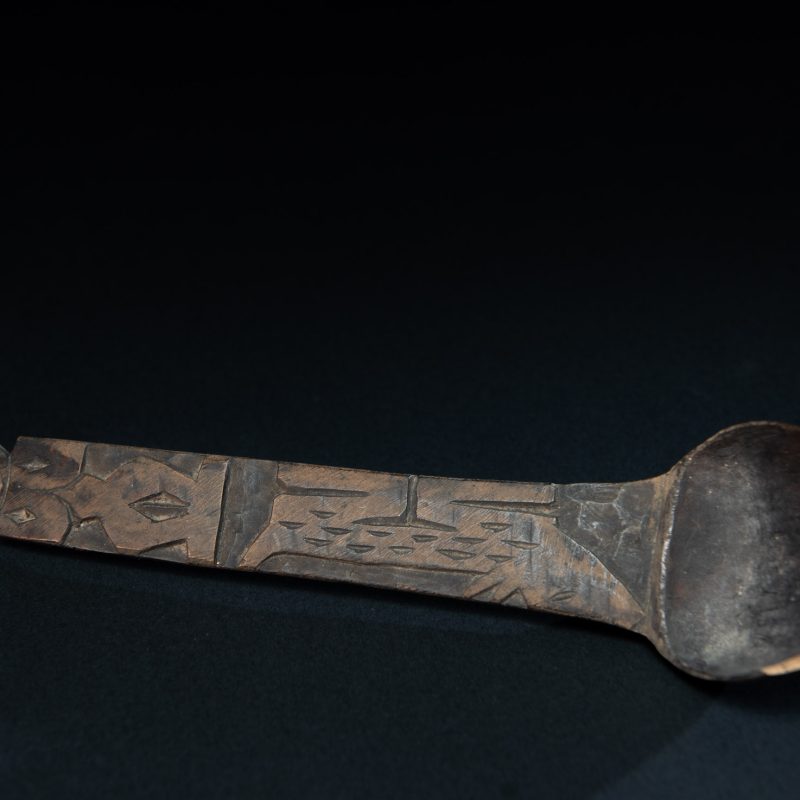 Old wooden spoon from the Paiwan tribe, carved with a standing figure and a deer at its feet.