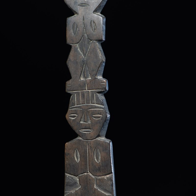 Ancient spoon from the Paiwan tribe, carved with two standing figures, one above the other.