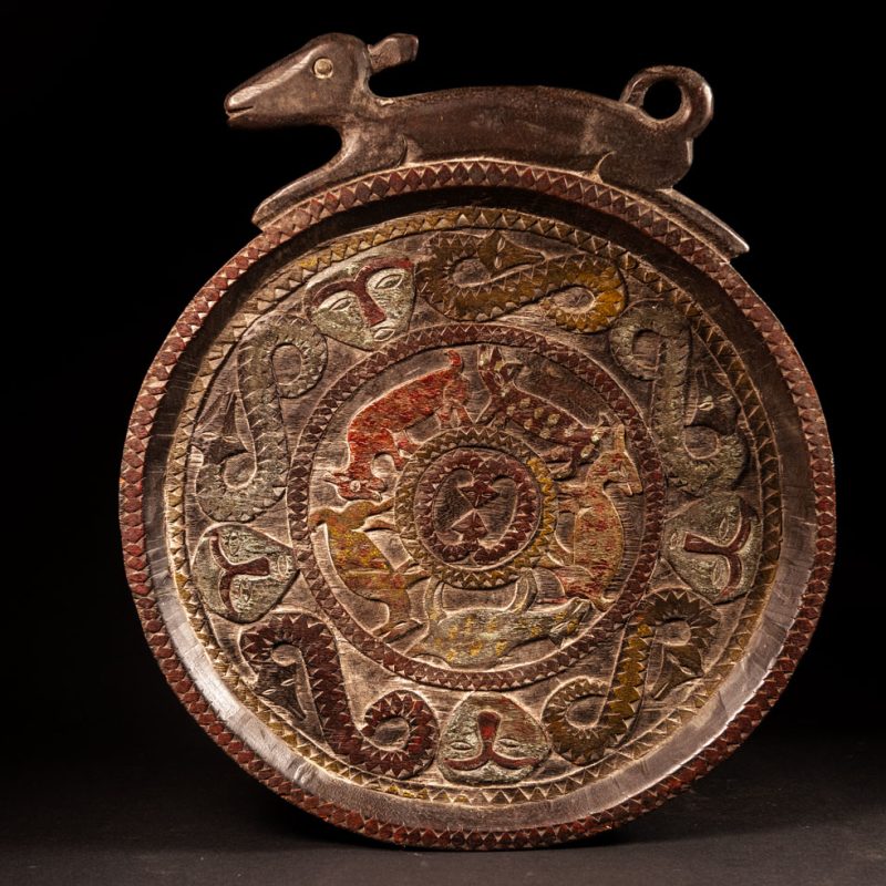 Ceremonial Tray from the Paiwan Tribe Carved with snakes, human faces, and game animals such as deer and wild boar, topped with a sculpture of a deer .