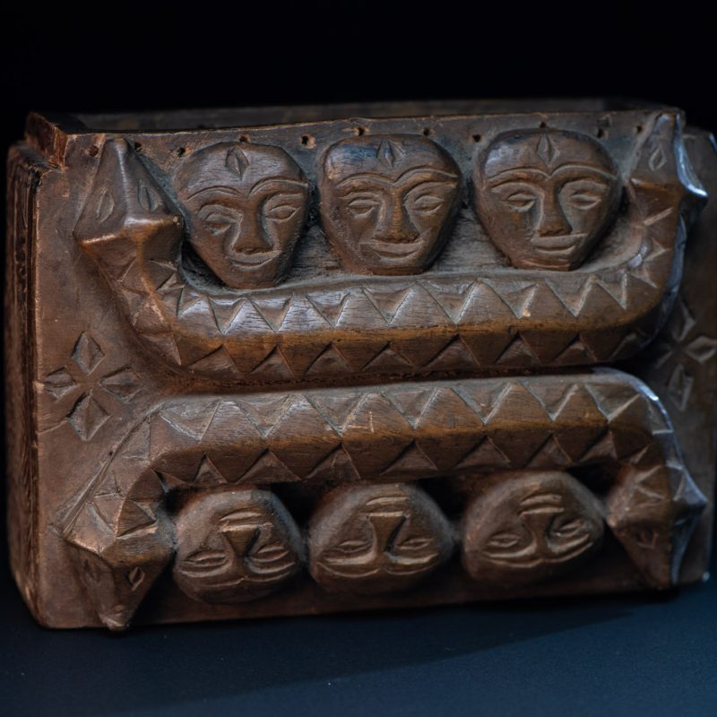 Paiwan tribe ancient shaman box in wood carved with two designs mirrored of three human head set up on a two heads snake .