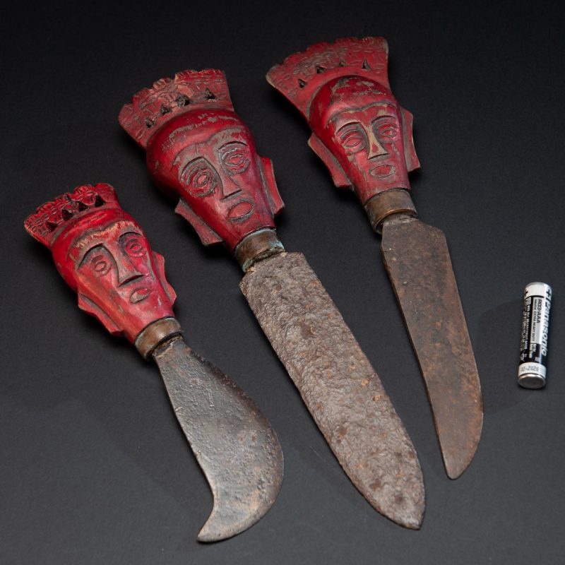 Set of three shamanic knifes from the Paiwan tribe, intended for sacred rituals. Painted in red and carved with a human head surmounted by additional heads, it reflects the typical style of Paiwan shamans and healers, who are in charge of the tribe’s physical and spiritual well-being. These shamanic knifes were used to cut herbs, beetle nuts, little animals and each one have a precise function.