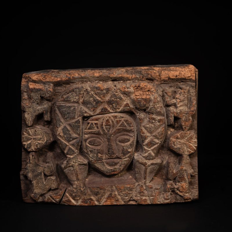 Paiwan tribe - Eave fragment carved with a central face surrounded by a sacred snake, and two faces flanked by deer.